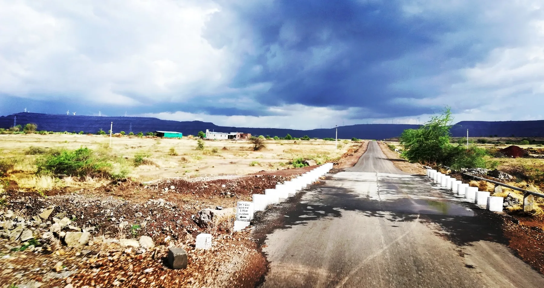 Road leading toward dramatic monsoon clouds